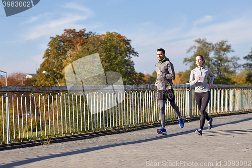 Image of happy couple running outdoors