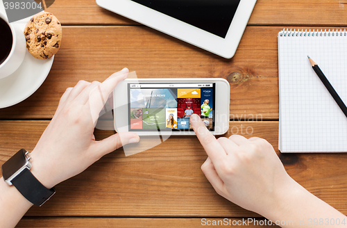 Image of close up of woman with smartphone on wooden table