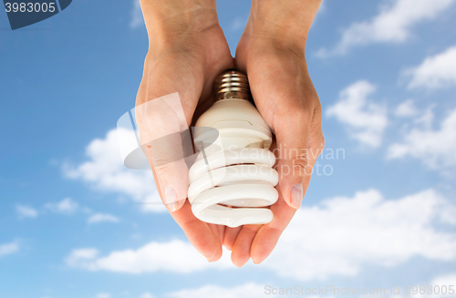 Image of close up of hands holding energy saving lightbulb