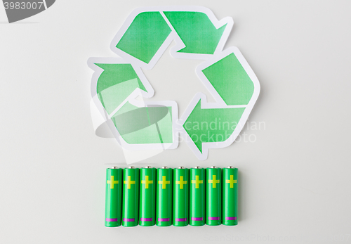 Image of close up of batteries and green recycling symbol