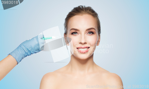 Image of woman face and hand with syringe making injection