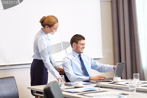 Image of businessman and secretary with laptop in office