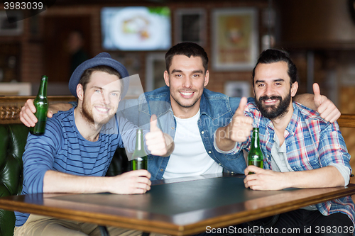 Image of happy male friends drinking beer at bar or pub