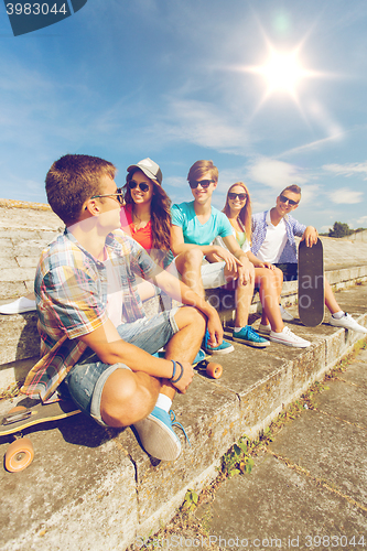 Image of group of smiling friends sitting on city street