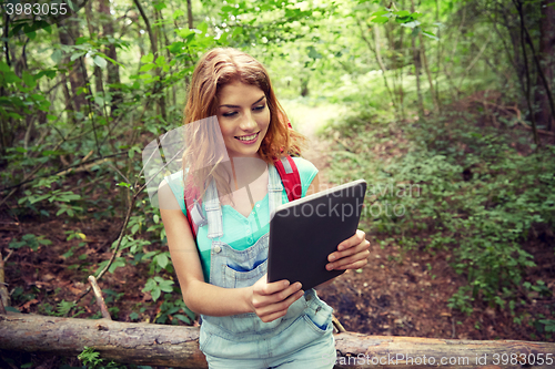 Image of happy woman with backpack and tablet pc in woods