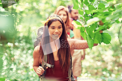 Image of group of smiling friends with backpacks hiking