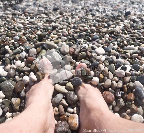 Image of male feet and pebbles