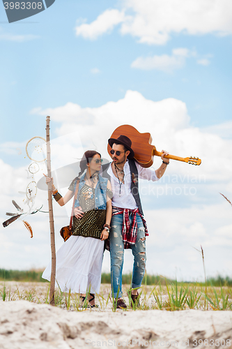 Image of Man and woman as boho hipsters against blue sky