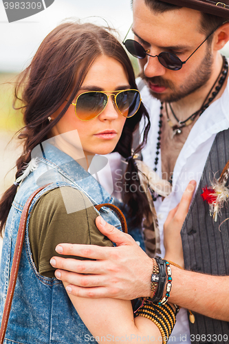 Image of Man and woman as boho hipsters against blue sky