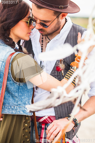Image of Man and woman as boho hipsters against blue sky