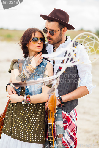 Image of Man and woman as boho hipsters against blue sky