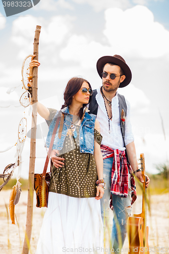 Image of Man and woman as boho hipsters against blue sky