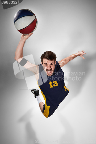 Image of Full length portrait of a basketball player with ball