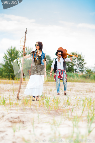 Image of Man and woman as boho hipsters against blue sky