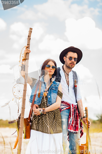 Image of Man and woman as boho hipsters against blue sky