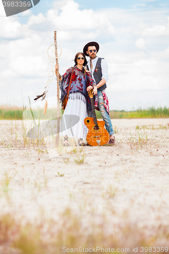 Image of Man and woman as boho hipsters against blue sky