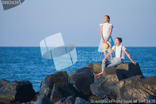 Image of Happy young romantic couple relaxing on the beach watching the sunset
