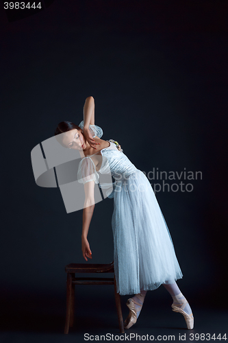 Image of Portrait of the classical ballerina in white dress on black background