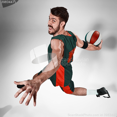 Image of Full length portrait of a basketball player with  ball against gray studio background