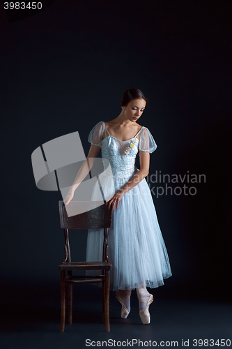 Image of Portrait of the classical ballerina in white dress on black background