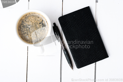 Image of Smartphone with notebook and cup of strong coffee