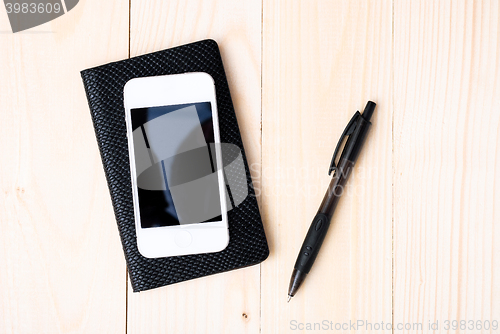 Image of Small notepad with pen and smartphone