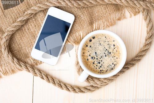 Image of Cup of coffee with foam on wooden table