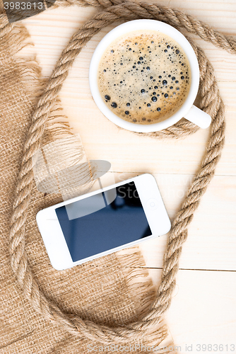 Image of Cup of coffee with foam on wooden table