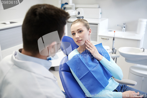 Image of male dentist with woman patient at clinic