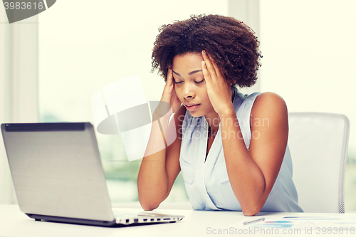 Image of african woman with laptop at office