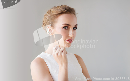 Image of smiling woman in white dress with diamond jewelry