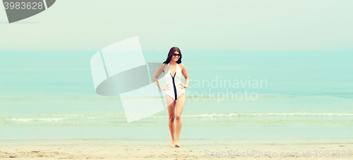 Image of young woman in swimsuit posing on beach