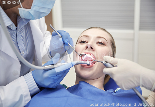 Image of close up of dentist treating female patient teeth