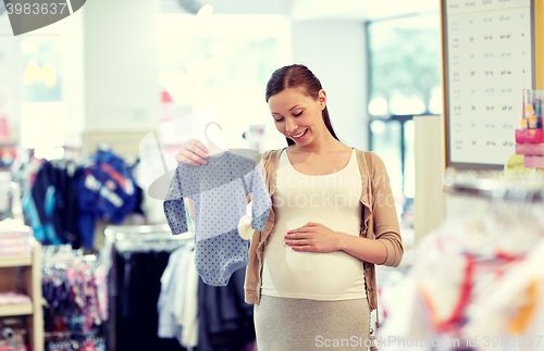 Image of happy pregnant woman shopping at clothing store