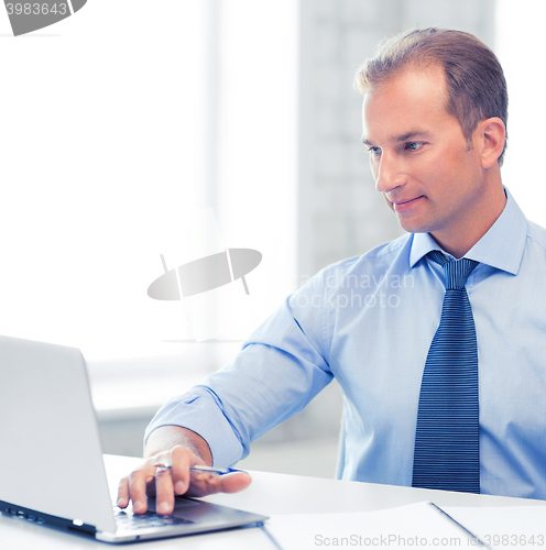 Image of miling businessman working in office