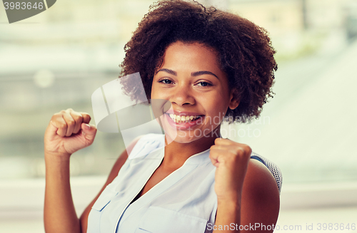 Image of happy african young woman with raised fists
