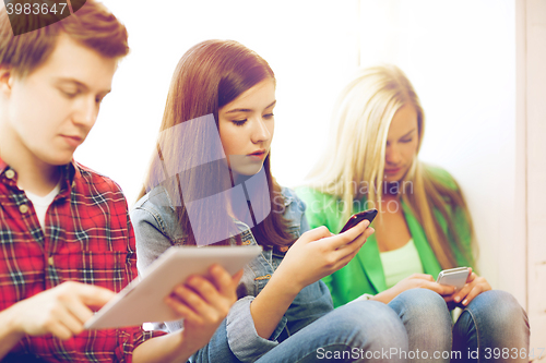 Image of students looking into devices at school