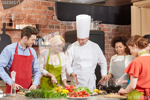 Image of happy friends and chef cook cooking in kitchen