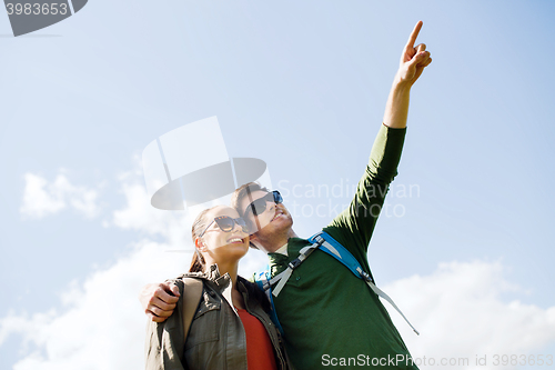 Image of happy couple with backpacks hiking outdoors