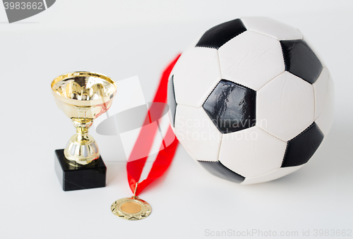 Image of close up of football ball, golden cup and medal