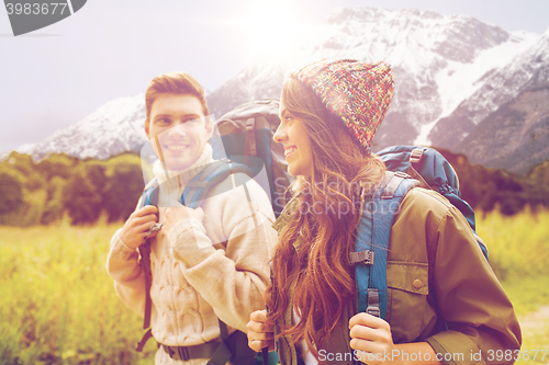Image of smiling couple with backpacks hiking