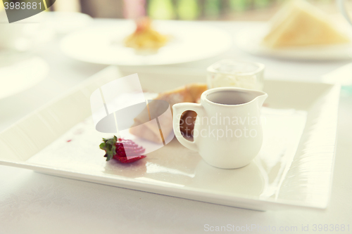 Image of close up of pancakes and honey or jam on plate