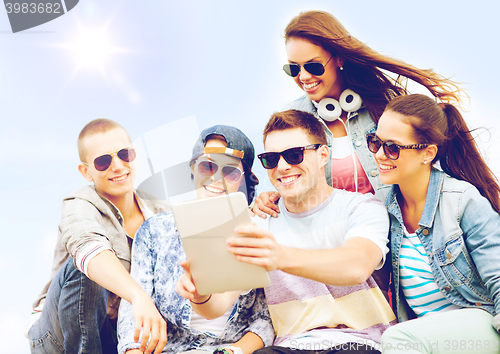 Image of group of teenagers looking at tablet pc