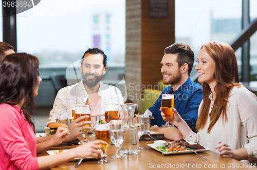 Image of friends dining and drinking beer at restaurant