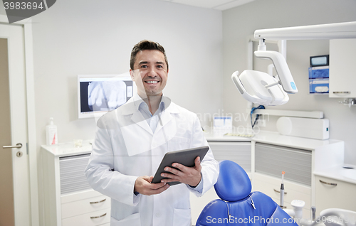 Image of happy male dentist with tablet pc at dental clinic