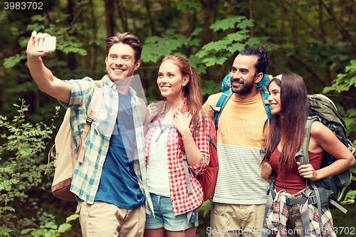 Image of friends with backpack taking selfie by smartphone