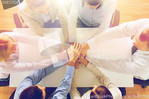 Image of close up of business team with hands on top