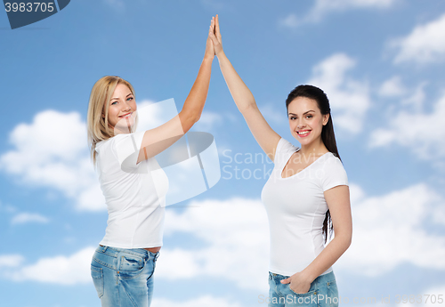 Image of group of happy different women in white t-shirts