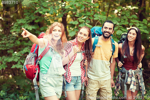 Image of group of smiling friends with backpacks hiking