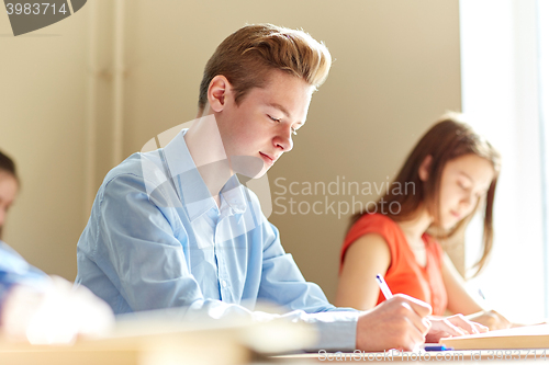 Image of group of students with books writing school test